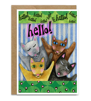 A greeting card with a brown kraft envelope, featuring an illustration of five cats in a playful, colorful design with the word 'hello!' in large pink letters. Artwork by Jennifer Lambein. 