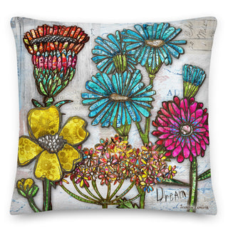 A throw pillow with colorful boho wildflowers and a white rustic background that says dream. Artwork by Jennifer Lambein. 