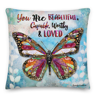 A throw pillow with a butterfly on it that says, "You are beautiful, capable, worthy and loved." Artwork by Jennifer Lambein. 