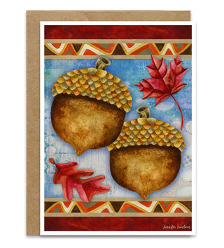 A greeting card with an autumn-themed illustration of two acorns, red maple leaves, and geometric borders, shown with a kraft envelope on a white background. Artwork by Jennifer Lambein. 