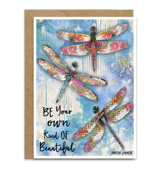 Greeting card with colorful dragonfly illustration and motivational quote that says be your own kind of beautiful on a blue sky background. Artwork by Jennifer Lambein. 