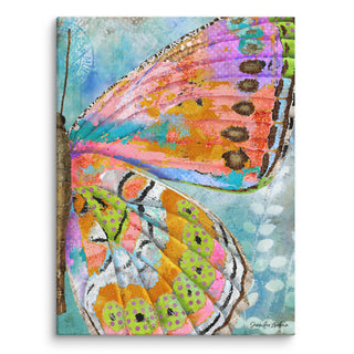 A canvas art print with a bright and whimsical pink and green butterfly wing on a blue sky background. Artwork by Jennifer Lambein. 