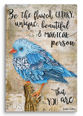 A canvas art print with a watercolor blue bird with wildflowers that says, "Be the flawed, quirky, unique, beautiful & magical person that you are." Artwork by Jennifer Lambein. 