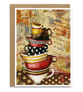 A greeting card card featuring a stacked arrangement of colorful teacups on a textured vintage-style background with script writing and warm earthy tones. The print is shown with a kraft envelope behind it on a white background. Artwork by Jennifer Lambein. 