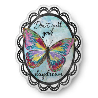 An oval throw pillow with a colorful butterfly on a blue sky background that says, "Don't quit your daydream." Artwork by Jennifer Lambein. 