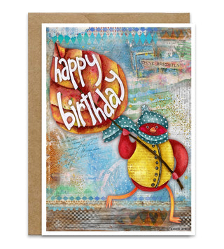 An autumn birthday greeting card with a kraft envelope, featuring a whimsical illustration of a red bird wearing a blue polka-dot scarf, hat, and yellow vest, holding a large fall leaf with the words 'happy birthday' in white script. The background of the card has a textured multicolor collage style. Artwork by Jennifer Lambein