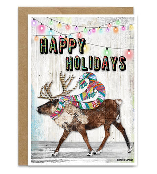 A greeting card with a cute whimsically painted reindeer with a colorful scarf. The card says, "Happy Holidays" in colorful lettering. There are Christmas lights hanging in the background. Artwork by Jennifer Lambein. 