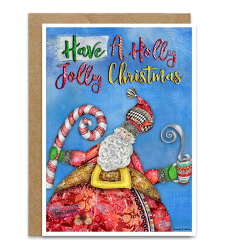 A Christmas greeting card with a kraft envelope, featuring a whimsical Santa illustration on a blue background with the text 'Have A Holly Jolly Christmas' in colorful lettering. Santa is holding a candy cane and hot cocoa. Artwork by Jennifer Lambein. 