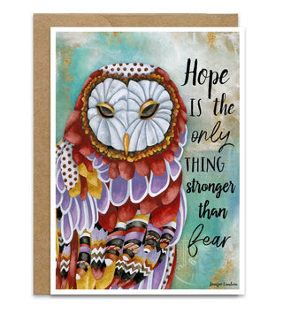 A greeting card with a kraft envelope, featuring a colorful watercolor owl illustration and the quote 'Hope is the only thing stronger than fear'. Artwork  by Jennifer Lambein. 
