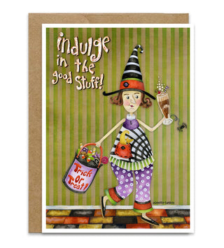 A Halloween-themed greeting card featuring a whimsical illustration of a witch carrying a bucket of 'Trick or Treat Stuff' and holding a milkshake and cute spider, with the text 'indulge in the good Stuff!' on a green striped background. The card is shown with a brown kraft envelope behind it on a white background. Artwork by Jennifer Lambein. 