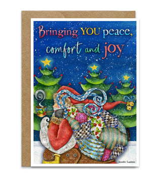 A Christmas greeting card with a kraft envelope, featuring a whimsical illustration of Santa Claus and a large patchwork sack on a snowy ground under a starry blue sky. The card reads, 'Bringing YOU peace, comfort and joy' in colorful lettering. Artwork by Jennifer Lambein. 
