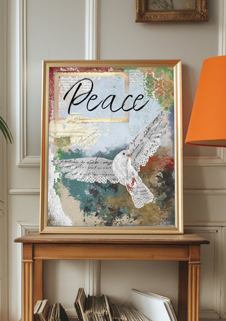 Framed artwork with dove and 'Peace' text on a wooden table against a wall.
