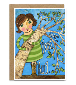 A greeting card with a kraft paper envelope behind it. The card features a whimsical illustration of a girl with brown hair hugging a tree with green leaves and branches. It says love, plant, hug. Artwork by Jennifer Lambein. 