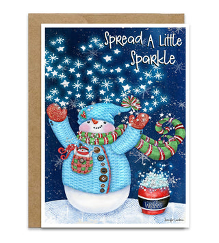 A Christmas greeting card with a kraft envelope, featuring an illustrated snowman in a blue knit outfit under a starry blue night sky with the text 'Spread A Little Sparkle'. He has a cute little white bird in his quilted pocket. Artwork by Jennifer Lambein. 