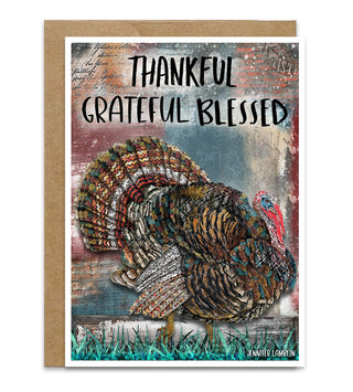 A greeting card with a kraft envelope, featuring a textured illustration of a turkey and the words 'THANKFUL GRATEFUL BLESSED' on a collage background. Artwork by Jennifer Lambein. 