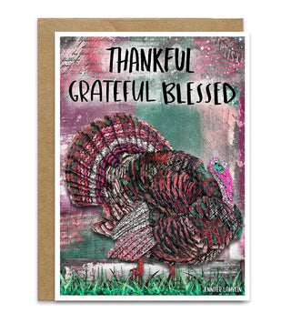 A greeting card with a kraft paper envelope, featuring a distressed, textured illustration of a turkey in red, brown, and black tones over a teal and pink background. The text 'THANKFUL GRATEFUL BLESSED' is printed at the top, and the artist's name 'JENNIFER LAMBEIN' appears at the bottom right.