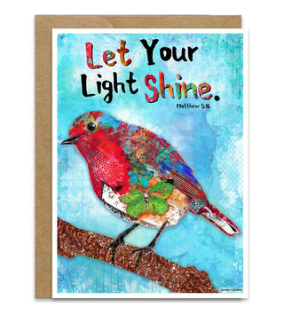A greeting card with a brown kraft envelope, featuring a colorful bird collage on a blue textured background with the text 'Let Your Light Shine. Hebrews 4:12'. Artwork by Jennifer Lambein. 